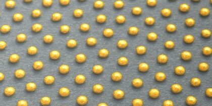 A schematic showing an array of spherical drops representative of nanoparticles formed by confined dewetting process